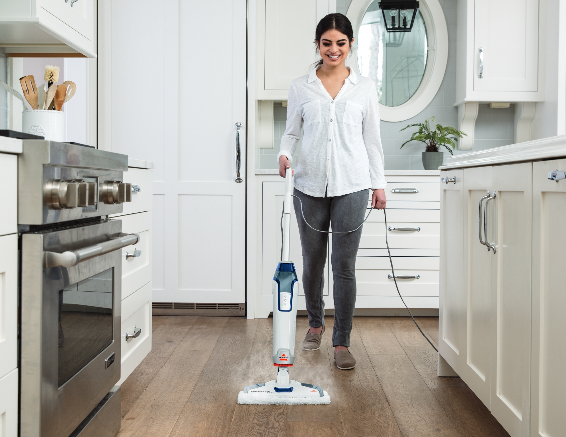 White and blue upright floor mop shown in a floor-cleaning lifestyle scene.