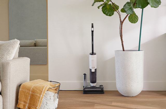 Tineco FLOOR ONE S5 Steam powered floor washer standing on its storage tray in a staged room